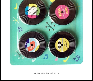 Close-up of four vintage vinyl record magnets in a retro musical-themed gift packaging