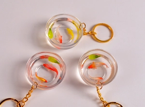 Dettaglio di un portachiavi con laghetto di carpe koi in resina e anello dorato