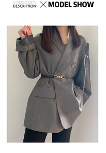 Close-up of grey oversized blazer cinched with a minimalist black leather waist belt