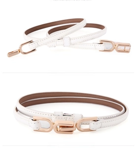 Close-up of white patent leather thin belt with elegant gold geometric metal buckle