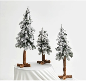 Detailed view of three frosted mini Christmas trees with snow-covered PE branches and wood bases