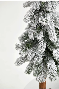 Detailed close-up of a mini flocked Christmas tree with realistic snow on green needles
