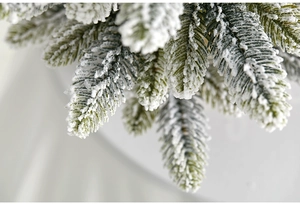 Macro close-up of realistic snow-flocked pine needles on a miniature Christmas tree