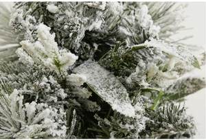 Close-up of frosted PE needles with thick white artificial snow for Christmas decor