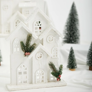 White wooden Christmas house ornament with lights and artificial pine branch decoration