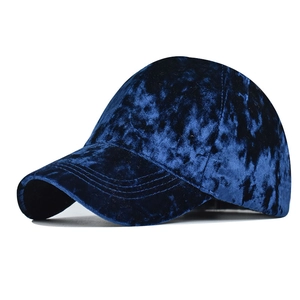 Detail of dark blue velvet chenille baseball cap showing textured fabric and curved brim