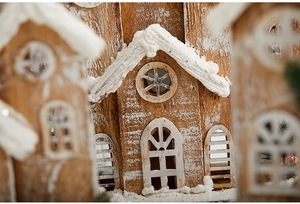 Macro view of a miniature wooden Christmas house with snow texture and soft lighting
