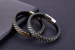 Detail of black leather braided men's bracelets with gold and silver steel clasps