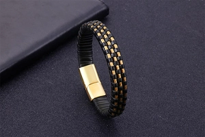 Detail of men's leather bracelet with gold magnetic clasp and black braided wire strap