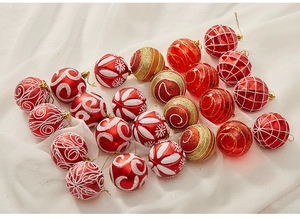 Detailed view of 6cm red and gold Christmas ornaments with white glitter on white cloth
