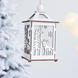 Wooden Christmas lantern with reindeer and snowflake cutouts in warm forest setting