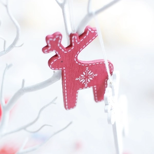Nordic wooden red reindeer ornament with white snowflake patterns and festive bell detail