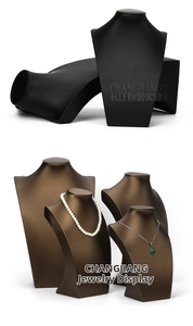 Detail of necklace display stands in black and brown leather with curved neck design