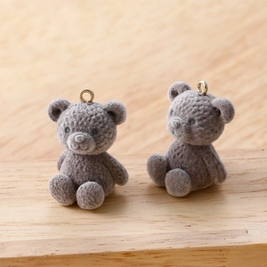 Macro detail of grey flocked teddy bear charms with gold loops for DIY jewelry making