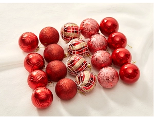 Close-up of red and gold Christmas ornaments with glitter and hand-painted patterns