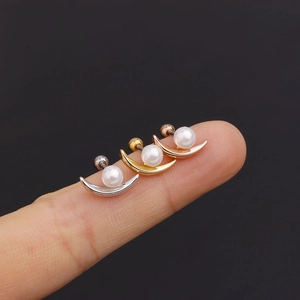 Macro shot of three crescent moon pearl earrings in silver gold and rose gold finishes