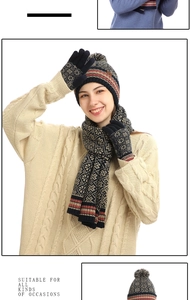 Macro detail of navy knit hat, scarf and gloves set with red and beige patterns