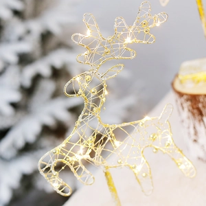 Golden iron mesh Christmas reindeer with warm LED lights against a white festive tree