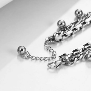 Detail of silver double-layered Cuban chain bracelet with moon beads and lobster clasp