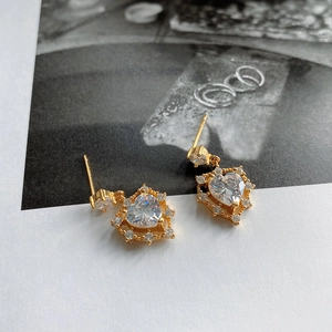 Macro detail of 925 silver heart stud earrings with cubic zirconia and gold plating