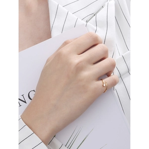 Minimalist adjustable gold ring with small zircon star worn by a model in office attire