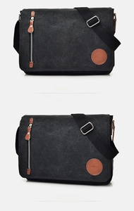 Detail of black canvas messenger bag featuring leather logo patch and zip pocket