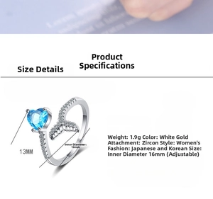Macro shot of silver-tone fishtail ring detail featuring heart-shaped blue zircon