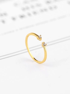 Close-up of gold minimalist open ring with two cubic zirconia in 4-prong settings