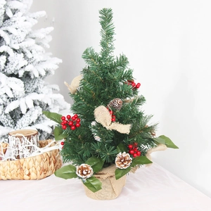 Mini snow-dusted Christmas tree with red berries, pine cones and burlap base decor
