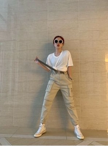 Detail of khaki cargo pants featuring large side pockets and elasticated cuffs for women