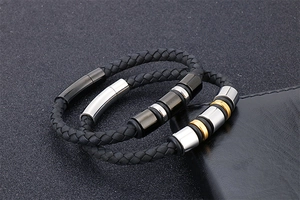 Close-up of black braided leather bracelets with metallic beads and magnetic clasps