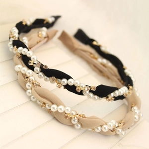 Detail of wave fabric headbands featuring woven faux pearls and rhinestones on wood