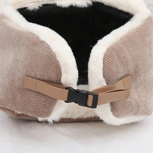 Close-up of adjustable buckle and strap on corduroy winter hat with faux fur lining