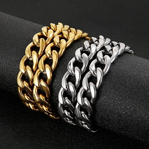 Close-up of gold and silver Cuban link bracelets on a black display stand with metallic shine