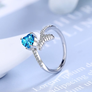 Elegant silver fishtail ring featuring a heart-shaped blue stone and white cubic zirconia
