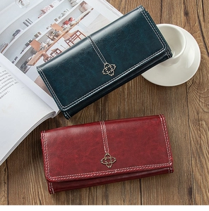 Detailed close-up of vintage long wallets with flower metal buckles and contrast stitching