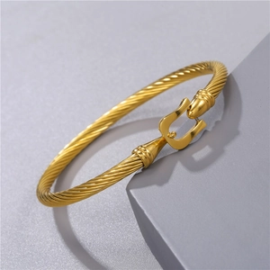 Detailed view of golden twisted rope cuff bracelet with unique U-shaped buckle design