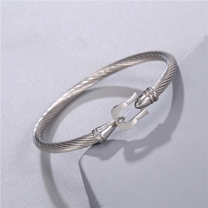 Close-up of silver stainless steel woven cuff bracelet with horseshoe clasp detail