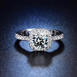 Macro shot of cushion cut moissanite ring with halo setting and pave diamond band