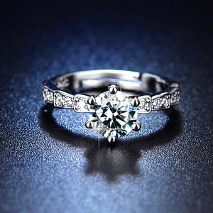 Macro shot of silver six-prong setting with large round diamond and pave side stones