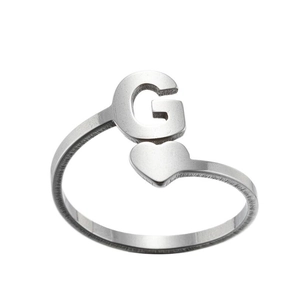 Detail of silver stainless steel adjustable ring featuring a letter G and heart design