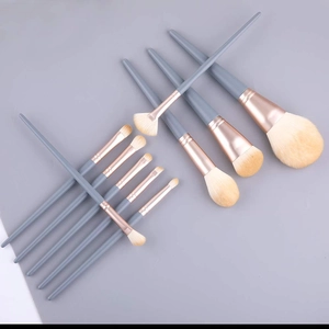 Close-up of 10-piece gray-blue makeup brush set with rose gold ferrules and soft bristles