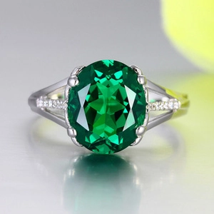Macro view of vintage silver ring with oval emerald gemstone and micro zircon accents