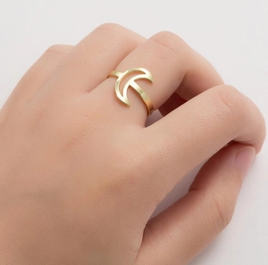 Detailed close-up of a gold crescent moon and star stainless steel ring on a finger