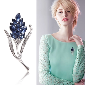 Blue crystal floral brooch with silver metal branches and diamonds on model and still life