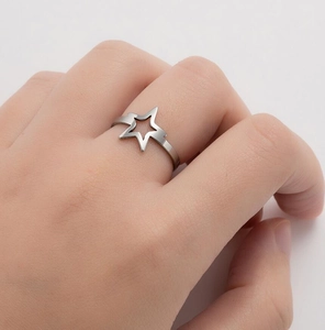 Close-up of adjustable silver star ring on model hand with hollow star detail