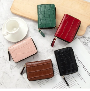 Flat lay of multiple crocodile pattern card holders in green, red, pink, brown, and black