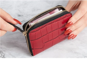 Close-up of red crocodile pattern card holder with gold zipper and spacious interior