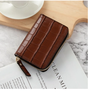Close-up of deep brown crocodile pattern leather card holder with smooth U-shaped zipper
