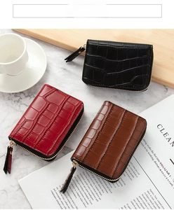 Detail of crocodile pattern mini card wallets with zipper closure and tassel in three colors